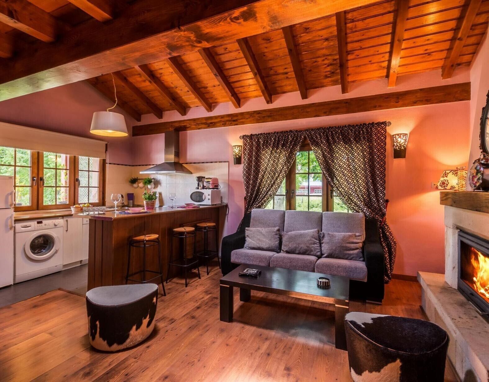 Una sala de estar acogedora con sofá, mesa de centro, reposapiés y chimenea.