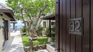 A residential property with a wooden gate, number 32, and a well-maintained garden with various plants and flowers.