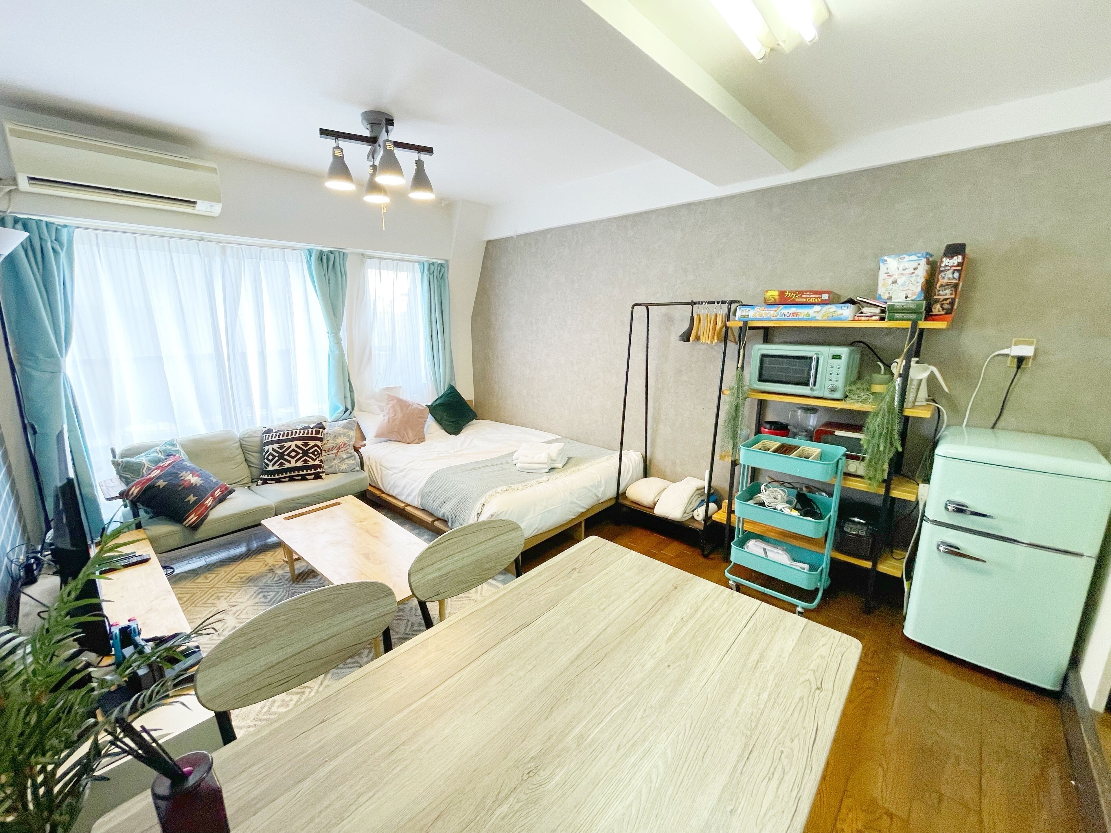 Une chambre d’hôtel compacte comprenant un lit, un canapé, une table à manger et une kitchenette.