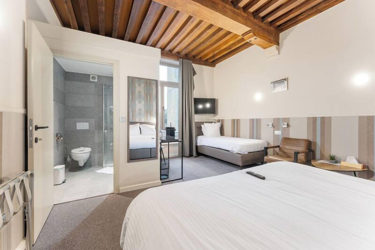 Een moderne hotelkamer met een groot bed, een douchegedeelte en een televisie.