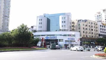 A multi-story building with a modern design, featuring a glass facade and a commercial ground floor.