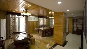 A modern interior with wooden paneling, a central island table, and a dining area. - Youth Holiday Hotel (Fuding)