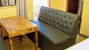 Una habitación con una mesa de madera y un sofá tapizado en gris.