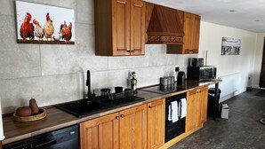 Een moderne keuken met houten kastjes, een vaatwasser, een spoelbak en een magnetron.