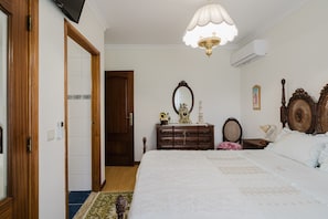 A bedroom with a bed, dresser, mirror, and a ceiling fan. - Country House 'Quinta Do Passal - Gondoriz' with Mountain View, Wi-Fi and Air Conditioning (Arcos de Valdevez)