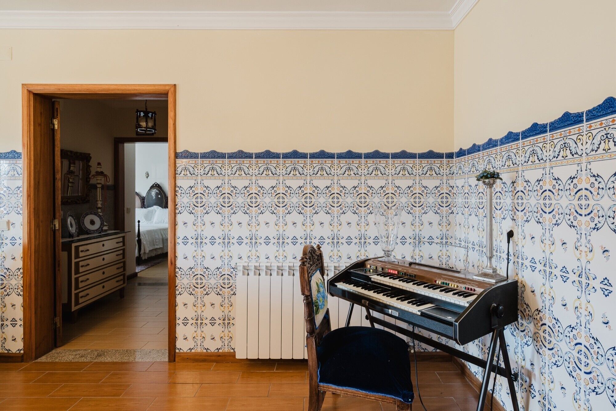 A room with a piano, a chair, and a radiator.