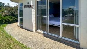 Ein Gebäude mit einem Schild, auf dem "Darkwood" steht, und einem Bett, das durch eine große Glastür zu sehen ist.