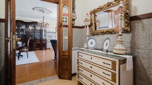 Ein Zimmer mit Holztür, einem Schrank mit Schubladen, einem Spiegel mit Zierrahmen und einer Chandelier.