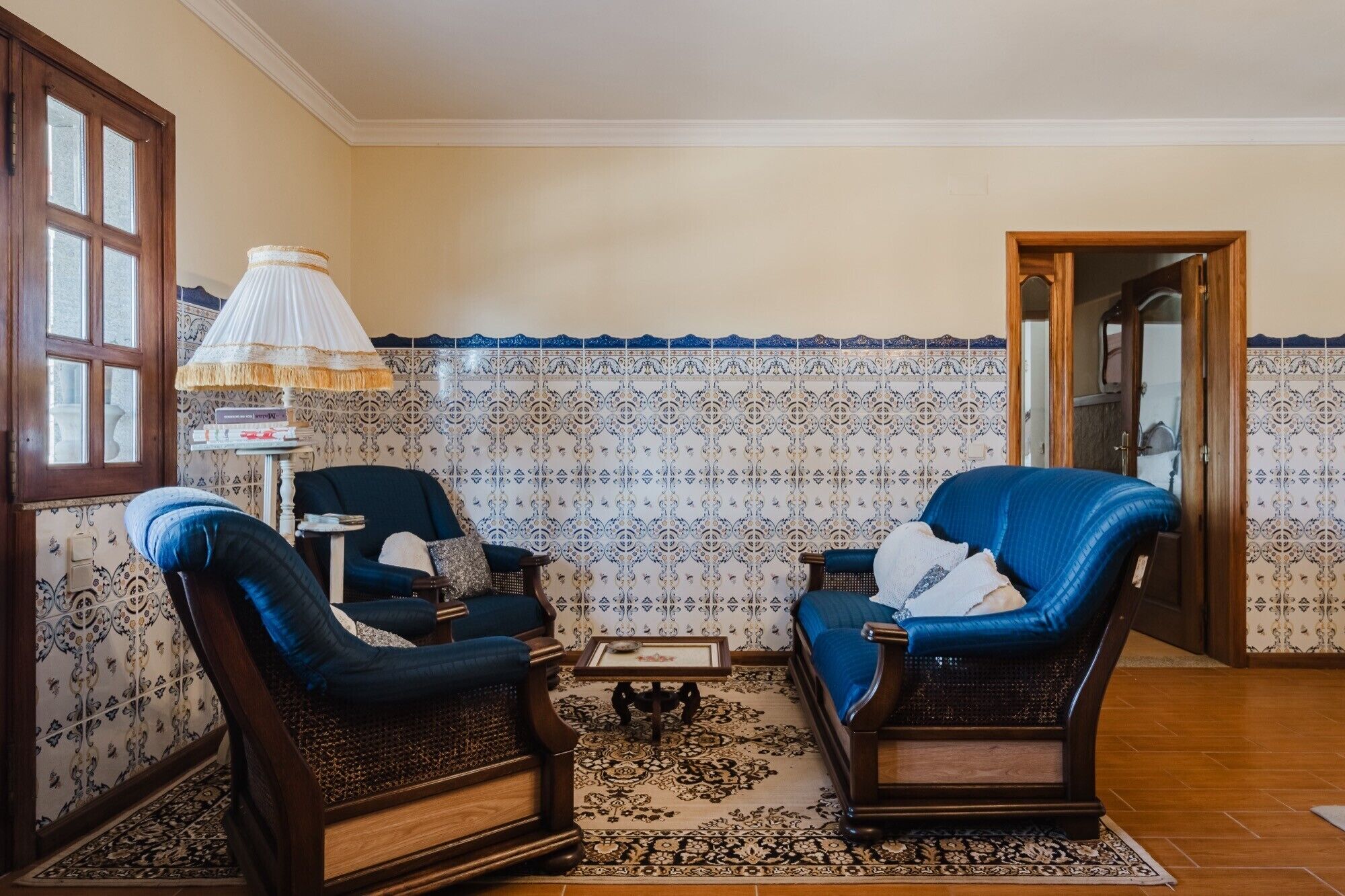 Una habitación con dos sillones, una mesita y un papel tapiz decorativo.