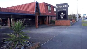 An indoor swimming pool facility named 'Aquarius Motor Inn' with a red roof and brick exterior. - Aquarious motor inn (Hamilton)