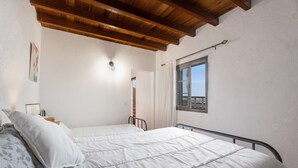 A bedroom with a bed, a window, and a wooden ceiling. - Holiday Home 'Mary Valverde' with Sea View, Private Terrace and Wi-Fi (Villa de Valverde)