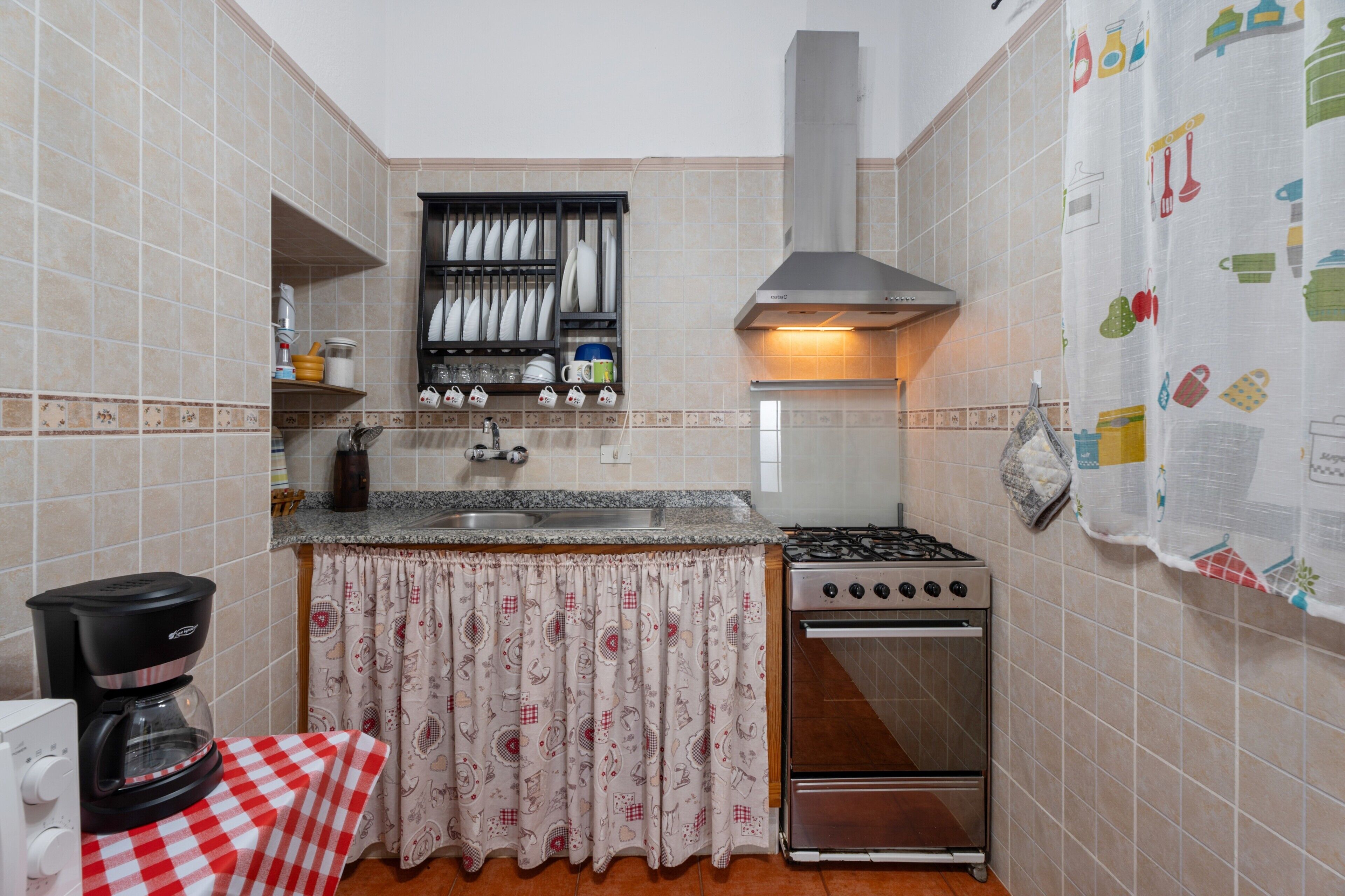 A kitchen with a stove, oven, and a coffee maker.