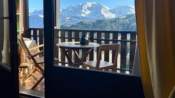 A wooden deck with a table and chairs, overlooking snow-capped mountains. - Chalet 'Face Au Mont Blanc, South Facing' with Mountain View, Private Terrace & Wi-Fi (Cordon)