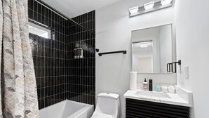 Ein modernes Badezimmer mit Badewanne, Toilette und Waschtisch.