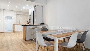 A modern kitchen with white cabinets, a marble backsplash, and a built-in oven.