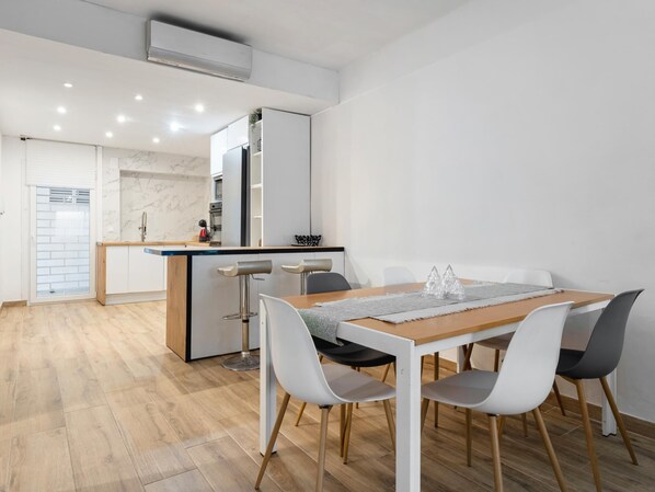 A modern kitchen with white cabinets, a marble backsplash, and a built-in oven.