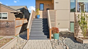 A modern building with a wooden staircase leading to a door marked with the number 4103. - Luxury 3 Bed/3 Bath NEW Home in Ruston (Tacoma)