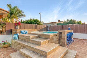 A wooden deck with steps leading to a hot tub, surrounded by a fence and palm trees. - Villa 'Mediterraneo' with Private Pool, Wi-Fi and Air Conditioning (Oliva)