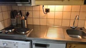 Una cocina equipada con estufa, lavaplatos y lavamanos.