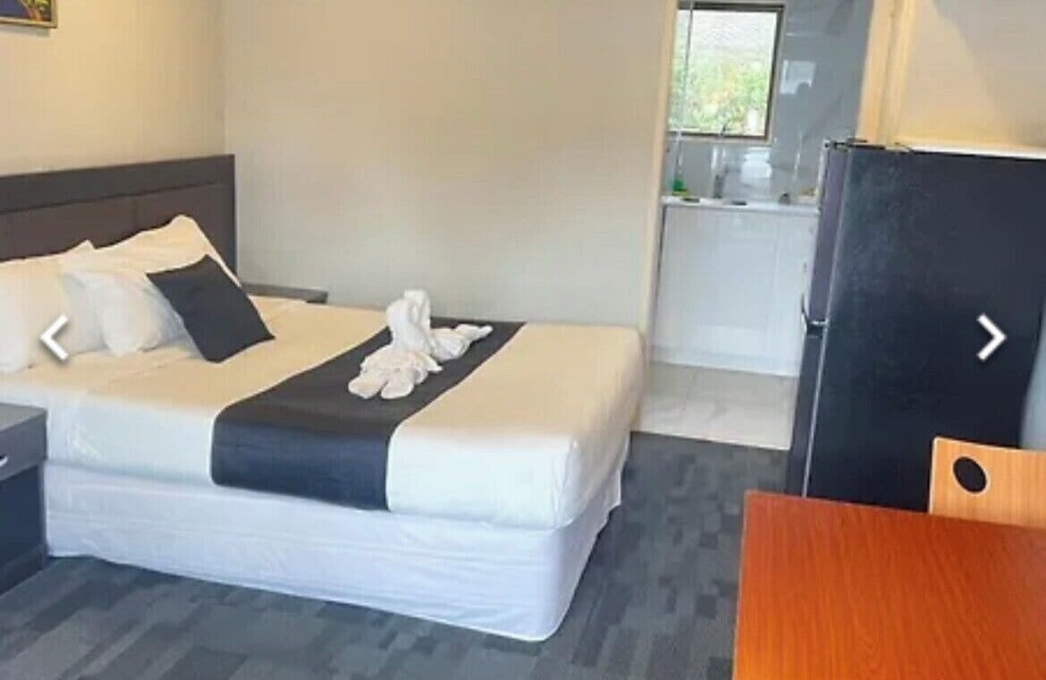 Une chambre d’hôtel équipée d’un lit, d’un bureau, d’une chaise et d’une kitchenette.