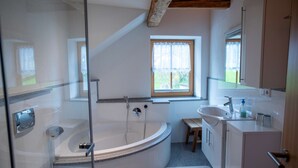 Ein Badezimmer mit einer Badewanne, einem Waschbecken und einem Fenster.