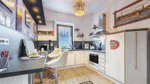 Une cuisine moderne avec un coin bar, un réfrigérateur et une table à manger.