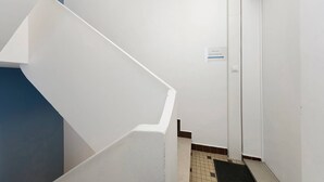 Eine weiße Treppe mit einem Schild, das 'Room 101' und 'Chambre 101' anzeigt.