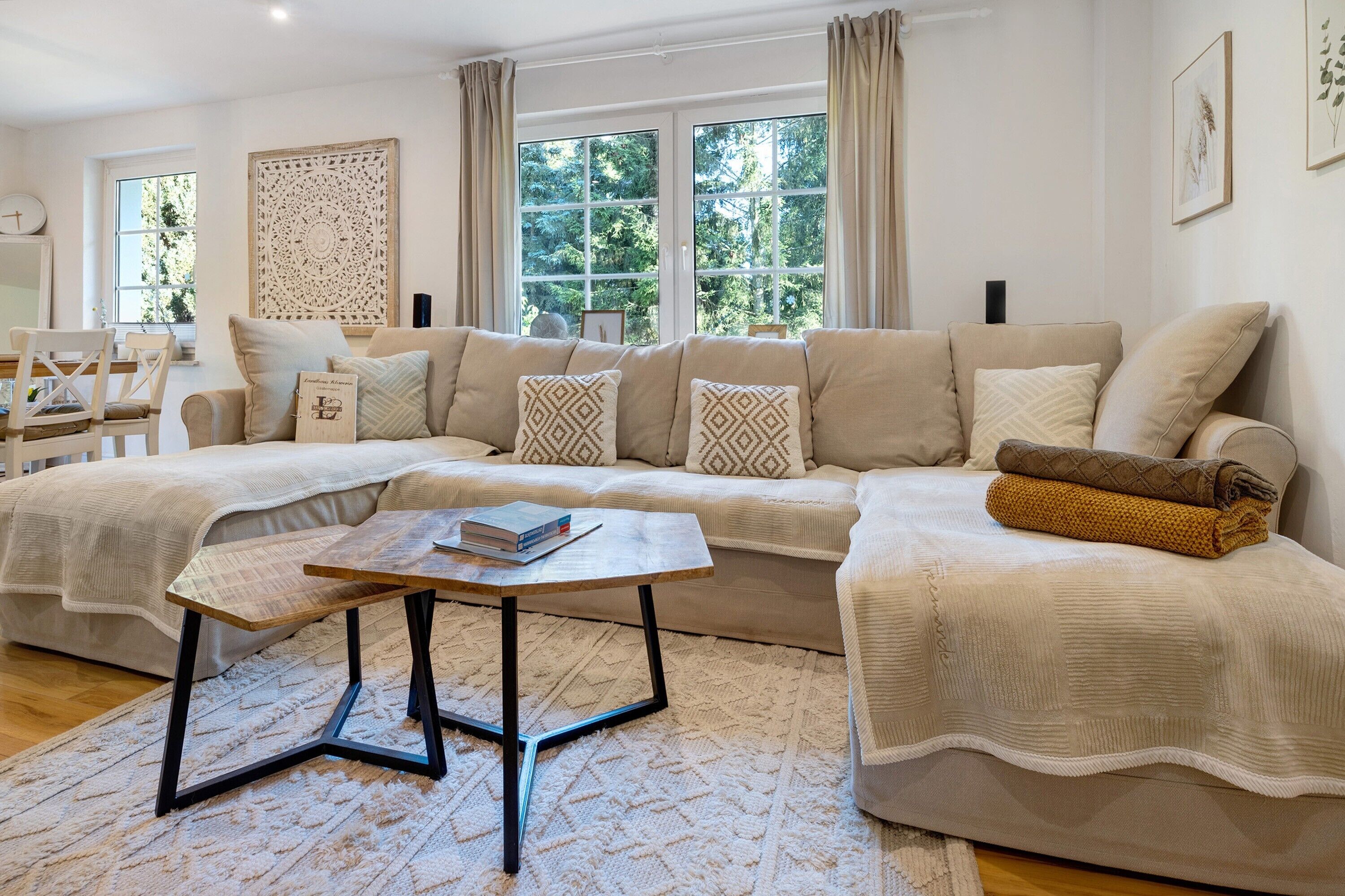 A living room with a sofa, a coffee table, and a window with curtains.