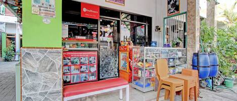 A RedDoorz store with a RedDoorz sign, a bench, and a display of RedDoorz products.