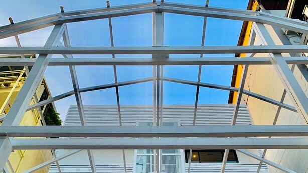 Un bâtiment moderne doté d’une façade en verre et d’une structure métallique blanche.