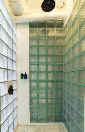 A room with a green grid-patterned partition, a white ceiling with a circular vent, and two bottles on the wall. - Easy sunday (Bangkok)