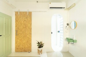 A bathroom with a wooden door, a green sink, and a mirror. - Easy sunday (Bangkok)