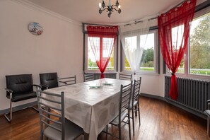 Un espace repas comprenant une table, des chaises et un lustre.