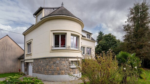 A two-story house with a curved facade, a stone base, and a balcony. - Holiday Home 'Maison Dans Le Morbihan' with Private Garden (Val d'Oust)