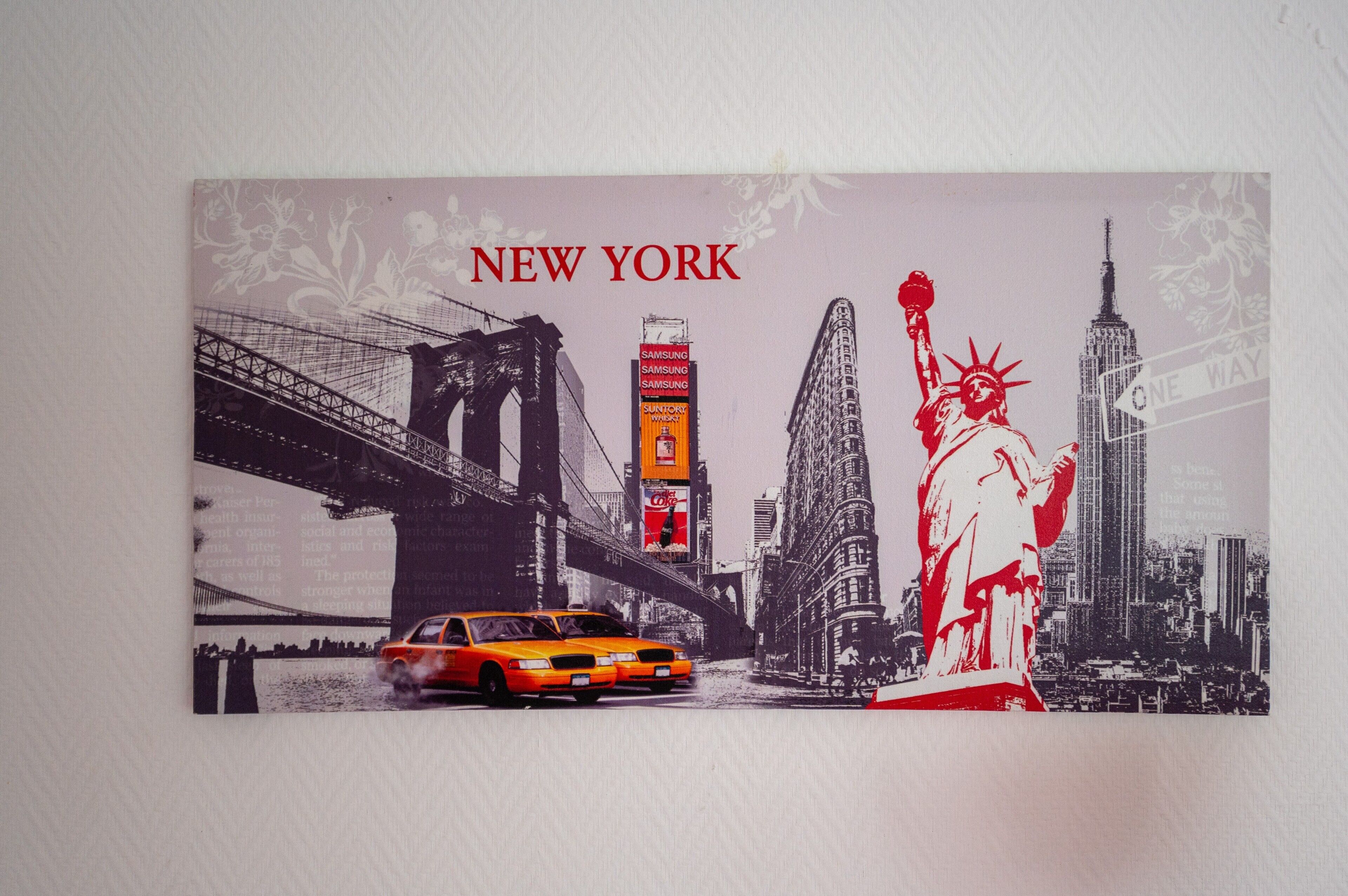 Stadsgezicht met de Vrijheidsbeeld en het Empire State Building, met de tekst 'NEW YORK'.