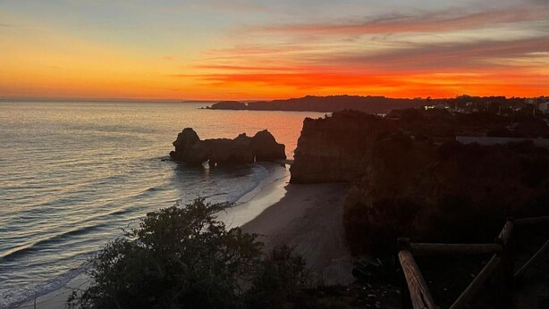 A coastal sunset view with rocky formations and a beach. - Apartment 'The Triple House' with Shared Pool, Private Terrace and Wi-Fi (Alvor)