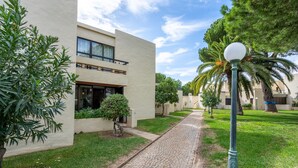 A pathway leading to a building with a modern design, a small tree, and a lamp post. - Apartment 'The Triple House' with Shared Pool, Private Terrace and Wi-Fi (Alvor)