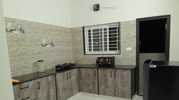 A kitchen with a gas stove, a toaster, and a refrigerator. - SAGAR NIWAS (Anekal)