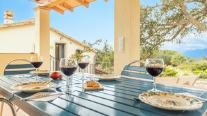 An outdoor dining area with a table set for two, featuring plates, glasses of red wine, and a small plate of pastries. - Country House 'Vinyoles 2' with Mountain View, Shared Pool and Wi-Fi (Quart)