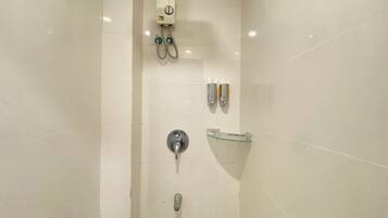 Un bany modern amb plat de dutxa de vidre, un escalfador fixat a la paret i un lavabo de vidre.