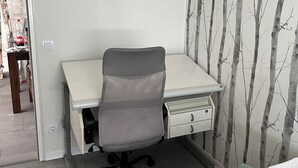 A bedroom with a bed, a desk with a chair, and a wardrobe. - Red Dot Eva (Werne)