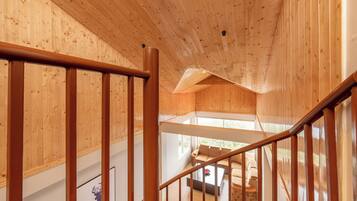 Un intérieur en bois avec un escalier menant à un espace de vie comprenant un canapé et une table basse.