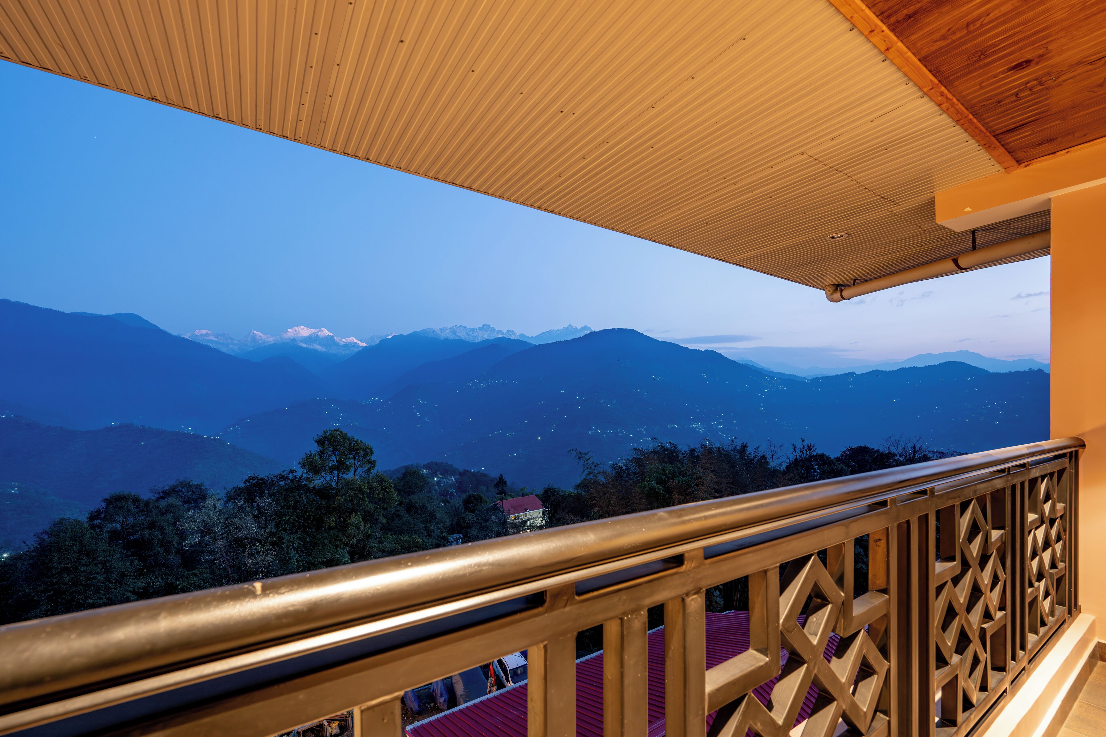 A balcony with a view of snow-capped mountains and a clear sky.