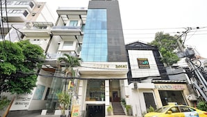 A hotel with a modern facade, a prominent glass section, and a visible entrance. - Queen Hotel Saigon Airport (Ho Chi Minh City)