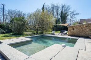 A swimming pool with clear water, surrounded by stone walls and a grassy area with trees. - Holiday Home 'Rose Antique' with Private Pool, Wi-Fi and Air Conditioning (VALREAS)
