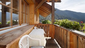 A wooden deck with a table and chairs, overlooking a mountainous landscape. - Apartment 'Inneroswalderhof  3' with Mountain View, Shared Garden and Wi-Fi (Anterselva di Sotto)