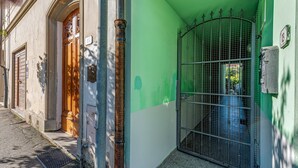 A building with a green door, a metal gate, and a number plaque. - Apartment 'Un Angolo Nel Verde A Empoli' with Shared Terrace, Wi-Fi and Air Conditioning (Empoli)