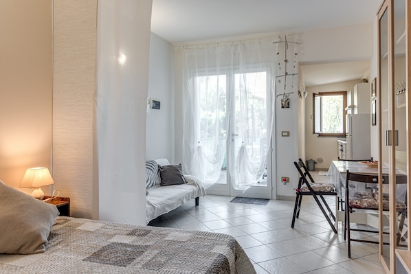 Une chambre avec un lit, une table de chevet et une vue sur la salle à manger.