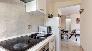 A modern kitchen with a gas stove, microwave, and refrigerator. - Apartment 'Un Angolo Nel Verde A Empoli' with Shared Terrace, Wi-Fi and Air Conditioning (Empoli)