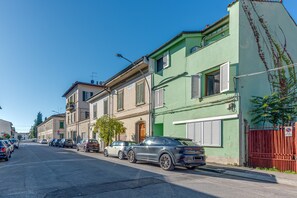 Une rue bordée de voitures garées et d’immeubles.